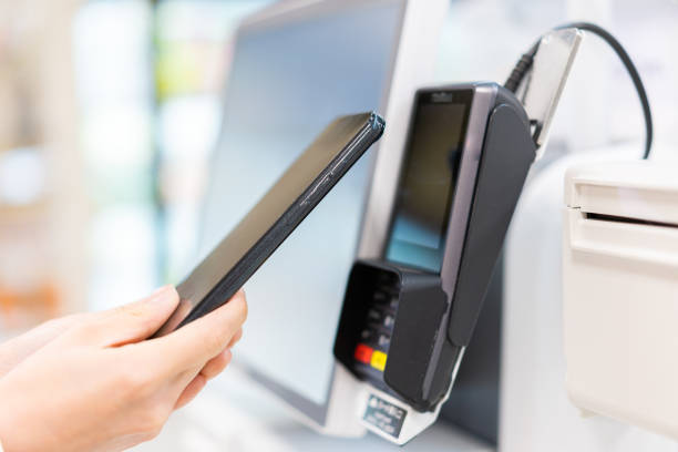 istock Young woman using self-checkout and e-money payment 1351767362