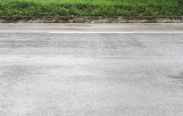 istock Concrete road and concrete curbs with green grass on background 1351767581
