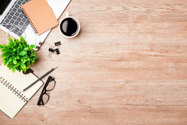 istock Work from home. desk office with laptop, blank notepad, coffee cup and pen on wood table. Flat lay top view copy spce. 1351772853