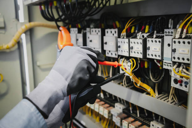 istock Electrical engineers test electrical installations and wiring on protective relays, measuring them with a multimeter. 1351772892