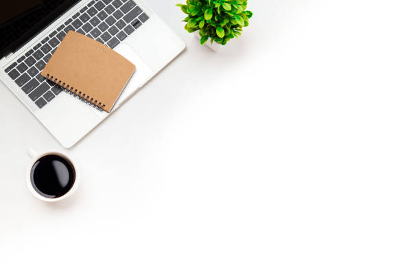 istock White office desk table with blank notebook, computer keyboard and other office supplies. Top view with copy space, flat lay. 1351772908