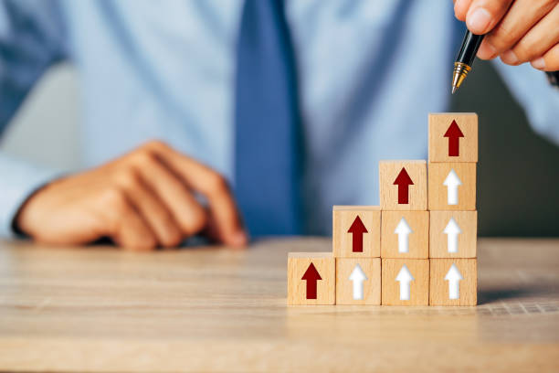 istock Hand arranging wood block stacking as step stair with arrow up.Ladder career path for business growth success process concept. 1351773008