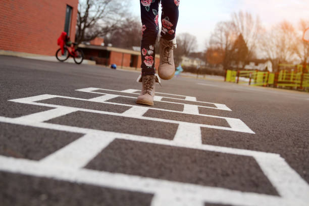 girl in beautiful boots playing hopscotch on a  playground outdoors - 7298 imagens e fotografias de stock