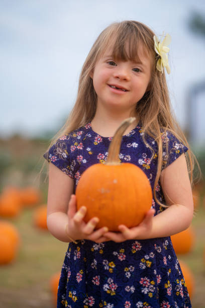 kleines mädchen findet den besten kürbis des pflasters - pumpkin child little girls pumpkin patch stock-fotos und bilder
