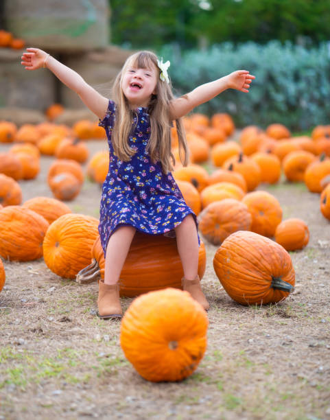 piccola ragazza ispanica così eccitata mentre si avvicina il ringraziamento - pumpkin child little girls pumpkin patch foto e immagini stock