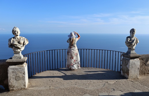 Ravello Campania, Italy - September 22, 2021: Girl with hat while admiring the view from the Infinity Terrace of Villa Cimbrone