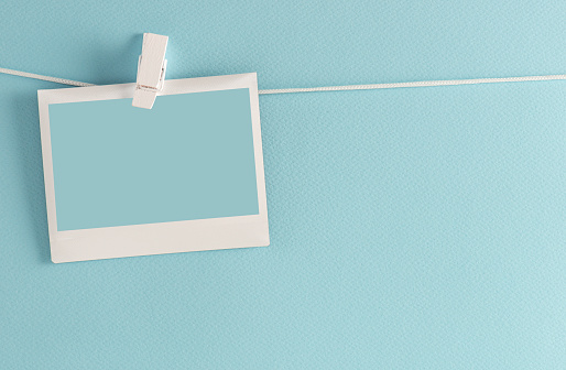 Photo frame on a clothesline, blue background.