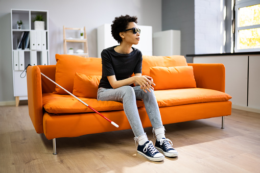 Person With Blindness Disability Sitting In Living Room