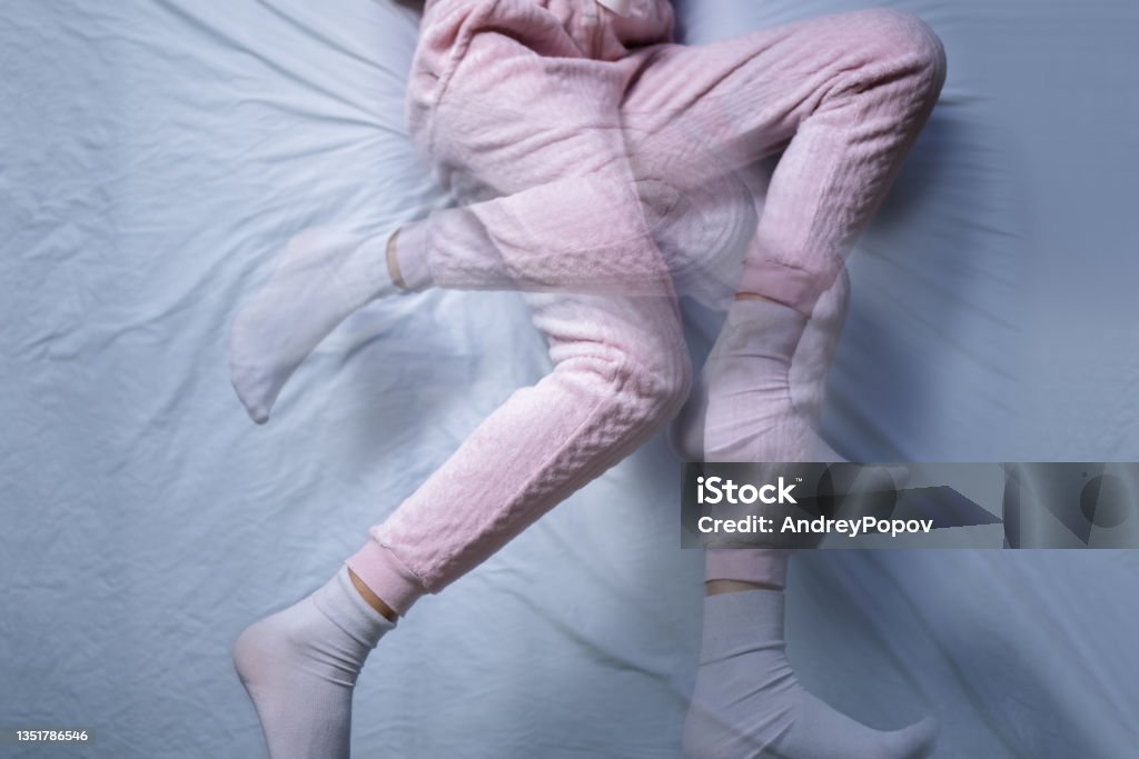 African American Woman With RLS - Restless Legs Syndrome African American Woman With RLS - Restless Legs Syndrome. Sleeping In Bed Leg Stock Photo