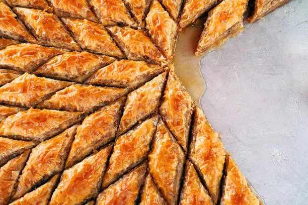 Delicious rhombus shaped Turkish village baklava with walnuts in a tray.