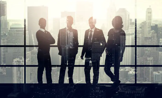 Photo of Portrait of a stylishly dressed young businessmen superimposed over a cityscape