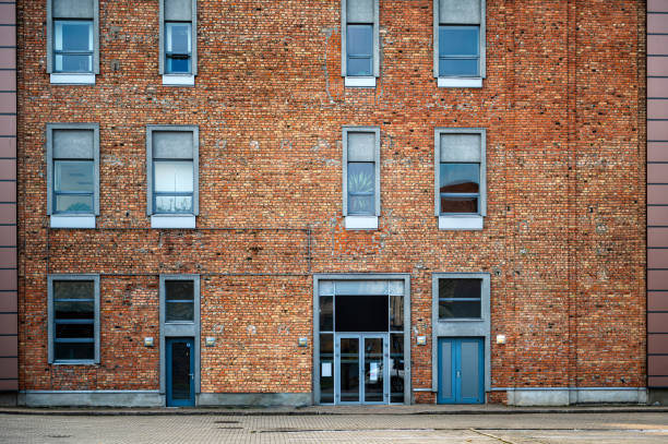 odnowiona ściana domu z czerwonej cegły z nowoczesnymi oknami i szklanymi drzwiami, widok z przodu - old ancient architecture apartment zdjęcia i obrazy z banku zdjęć