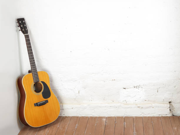 istock Musical instrument - Classic acoustic guitar white brick background 1351797853