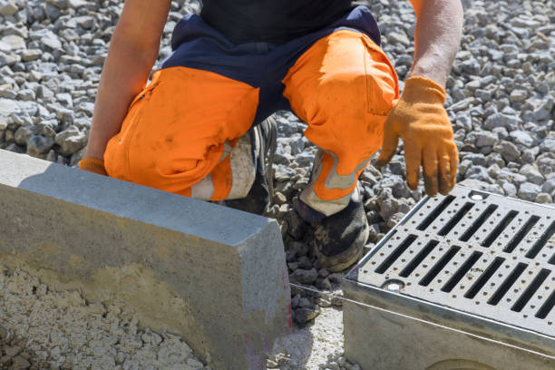 istock Municipal worker laying water drainage construction on well concrete 1351801565