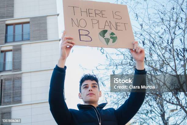 Arab Teenager With Climate Change Banner On Environment Demonstration Stock Photo - Download Image Now