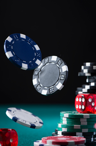 Casino Chips and Dices Flying Over Poker Green Table.