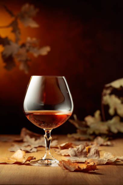 istock Snifter of brandy on an old oak table. 1351808306
