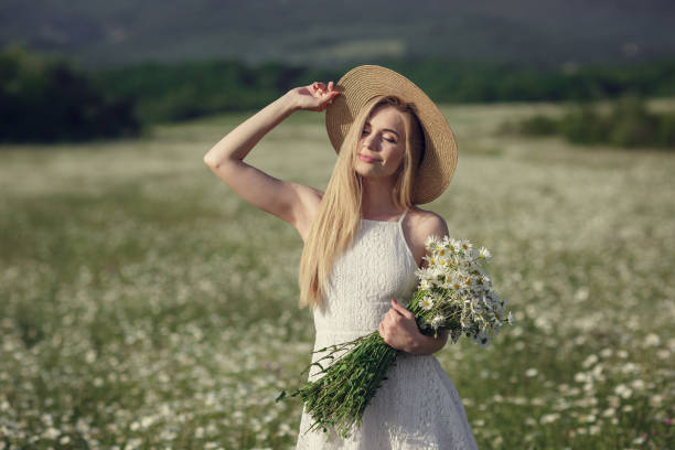 istock Beautiful woman enjoying daisy field 1351809790