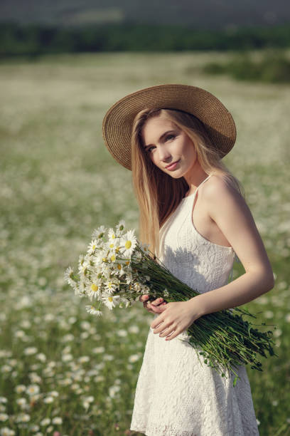 istock Beautiful woman enjoying daisy field 1351809791