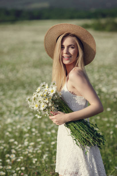 istock Beautiful woman enjoying daisy field 1351809818