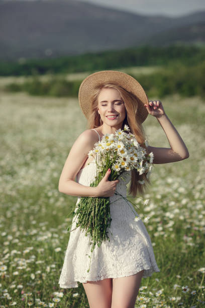 istock Beautiful woman enjoying daisy field 1351810424