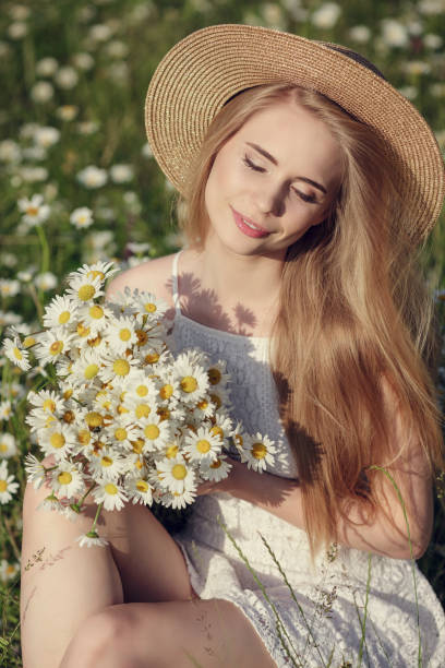 istock Beautiful woman enjoying daisy field 1351810428