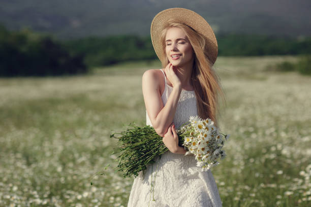 istock Beautiful woman enjoying daisy field 1351810430