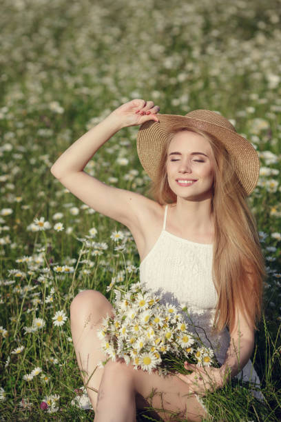 istock Beautiful woman enjoying daisy field 1351810512