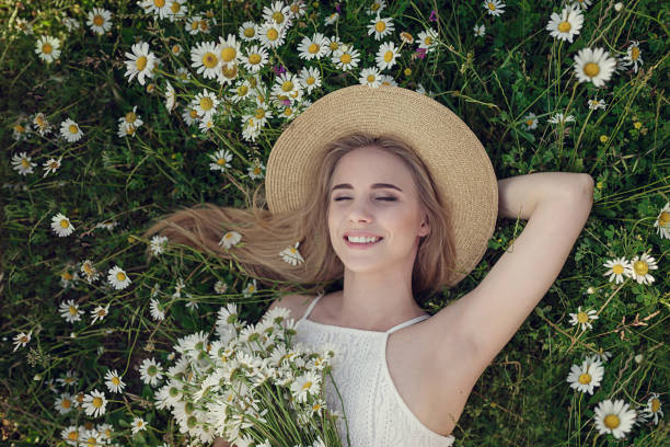 Beautiful woman enjoying daisy field