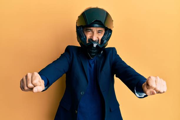 istock Middle age hispanic man wearing motorcycle helmet doing moto symbol with hands smiling with a happy and cool smile on face. showing teeth. 1351810573