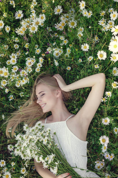 istock Beautiful woman enjoying daisy field 1351810631
