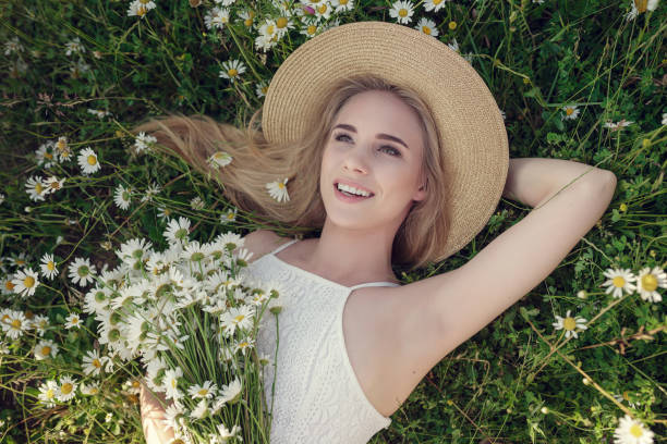istock Beautiful woman enjoying daisy field 1351810646