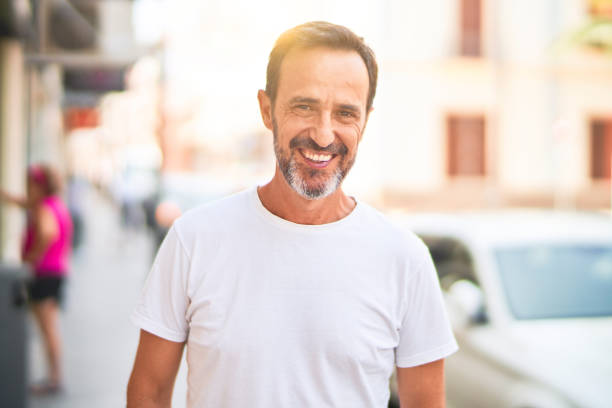 istock Middle age handsome man standing on the street smiling 1351810660