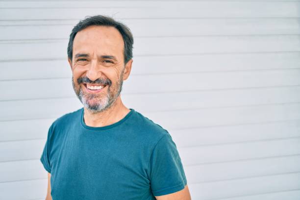 istock Middle age man with beard smiling happy outdoors leaning on the wall 1351810675