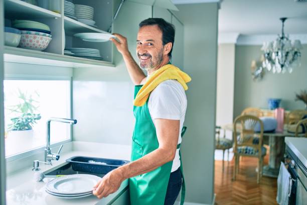 istock Middle age man with beard smiling happy washing dishes at home 1351810694