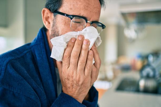 istock Middle age man feeling sick with cold and fever at home, ill with flu disease 1351810703