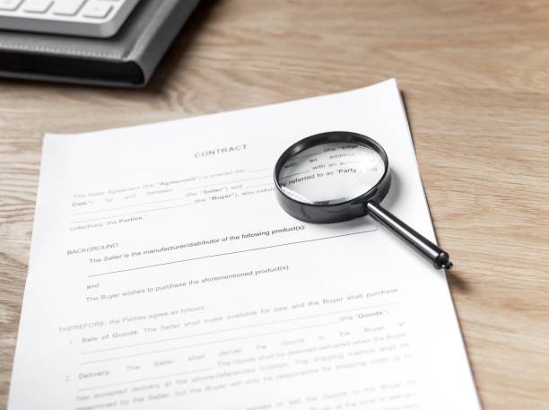 istock Magnifying glass on paper document, legal business contract 1351811700