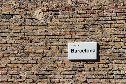 Brick wall with a plaque with the name of the street in Barcelona (Spain)
