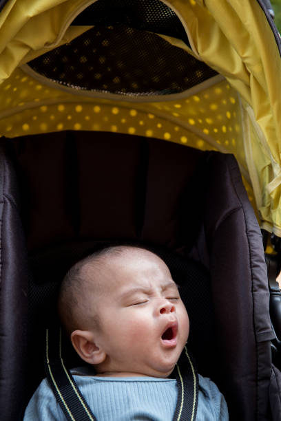 istock Asian baby yawning in stroller 1351813133