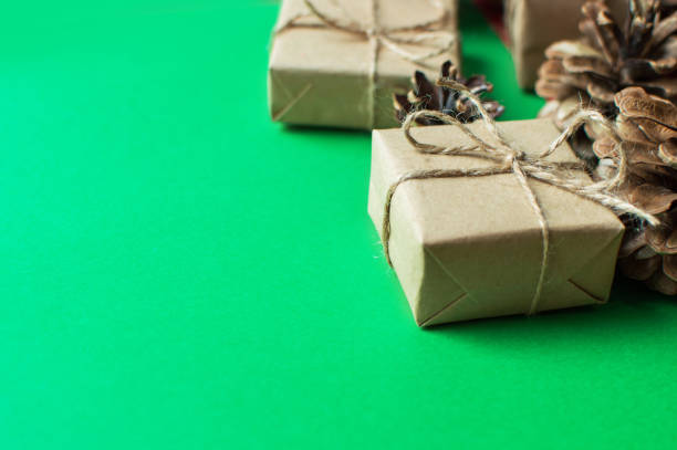 istock Festive concept - a gift with a bow and cones on a green and red background. 1351814323