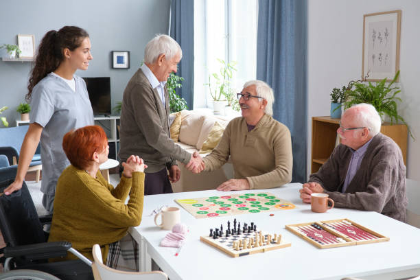 istock Senior people gathering to play board games 1351817615