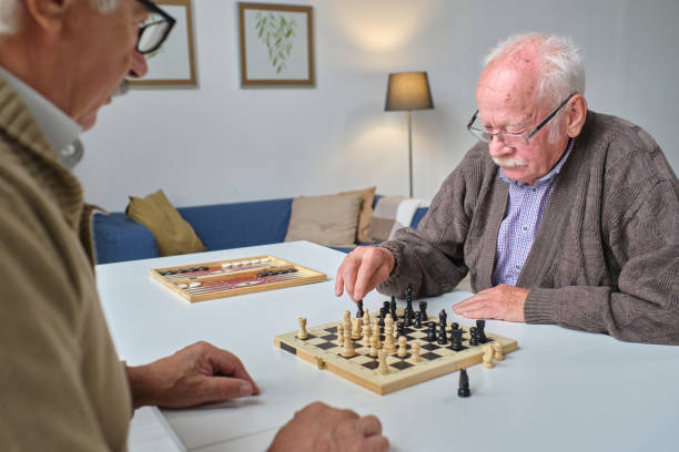 istock Senior people playing chess together 1351817666