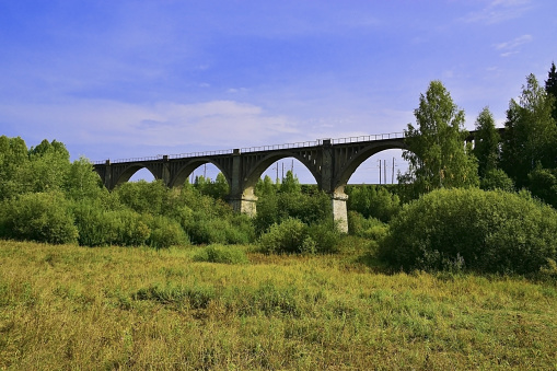 An old century-old railway viaduct in the Oktyabrsky district of the Perm region against the backdrop of the new Kazan-Yekaterinburg railway line.