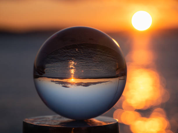 istock Sunset at the coast, seen through a glass ball. 1351818527