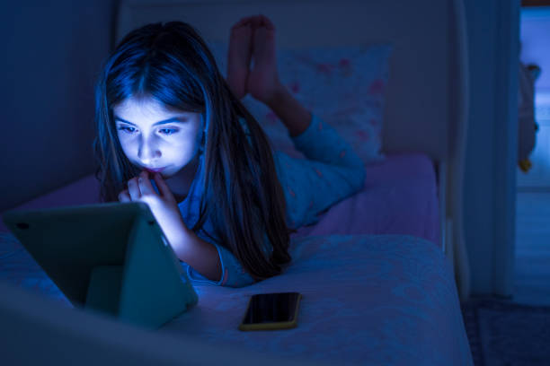 istock Littel girl using digital tablet at night 1351818770