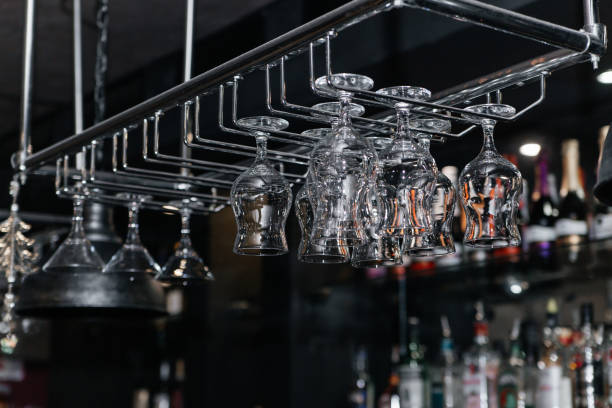 istock Empty and clean wine glasses hang upside down over the bar. 1351822487