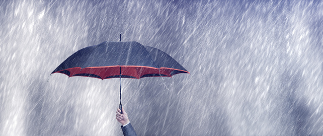 businessman holding umbrella on a rainy day