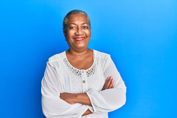 Senior african american woman wearing casual clothes happy face smiling with crossed arms looking at the camera. positive person. stock photo
