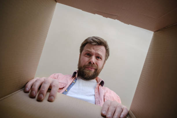 istock Man looks into an unpacked, delivered box and is upset because he received the wrong order. Unboxing inside view. 1351825541