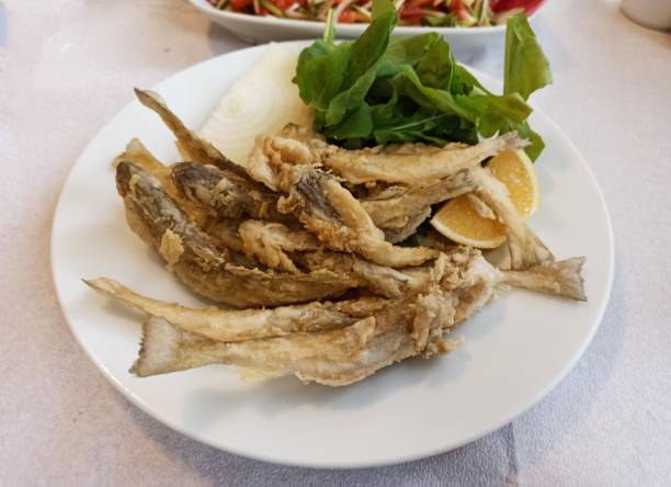 Traditional turkish fried whiting haddock fish with rocket onion salad in Istanbul turkey